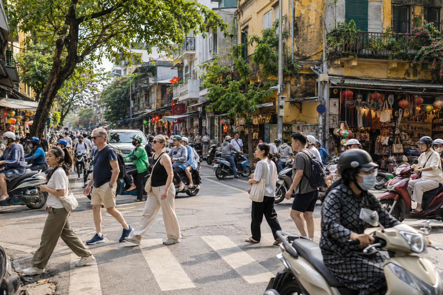 Pedestrians crossing a scooter-filled street in Hanoi's Old Quarter