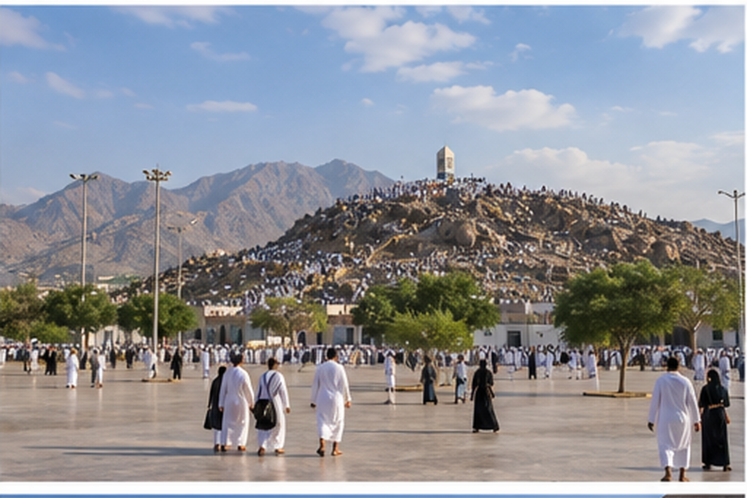 Pilgrims walking near Mount Arafat beneath the rocky mountains outside central Makkah